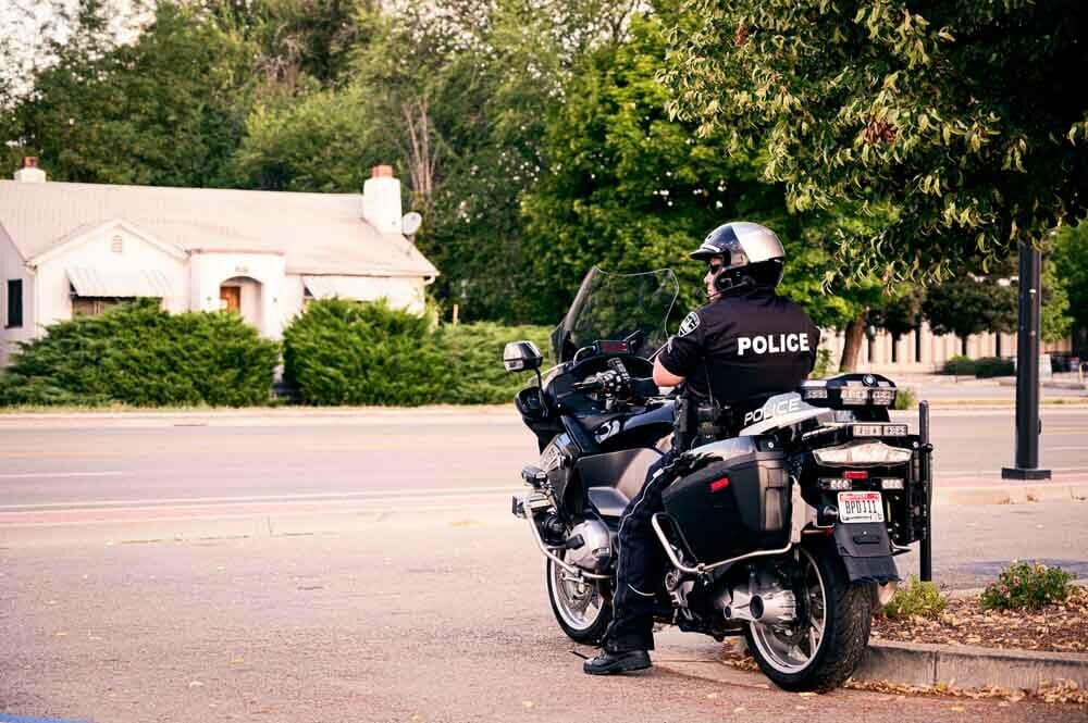 Un policier attendant au bord d'une route sur une moto pour faire des contrôles