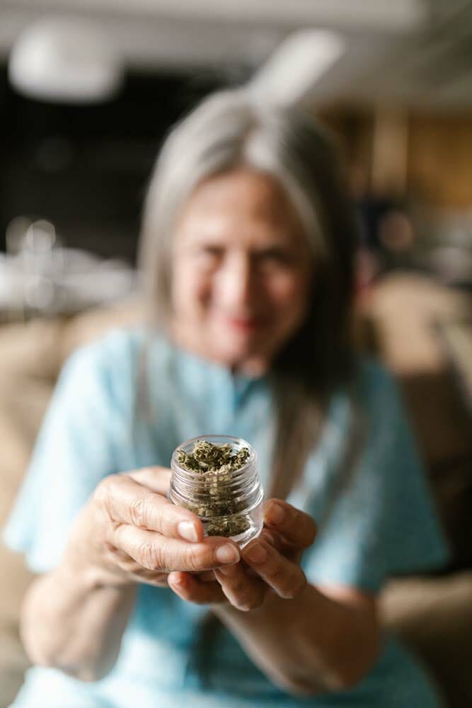 Une femme âgée portant un contenant avec du cannabis