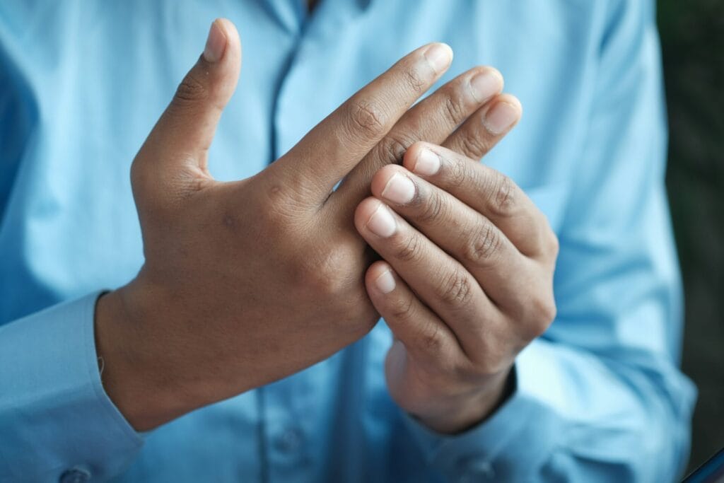 Une personne massant sa main pour soulager la douleur de l'arthrose