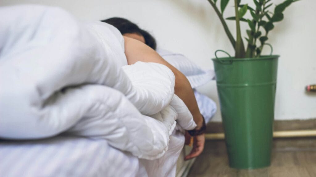 Une personne dormant paisiblement au lit, sous une couverture blanche